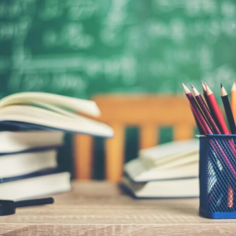 Βιβλία, μολυβοθήκη και υδρόγειος πάνω σε γραφείο στη σχολική αίθουσα