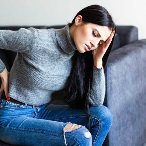 Γυναίκα πονά στο κεφάλι και στη μέση