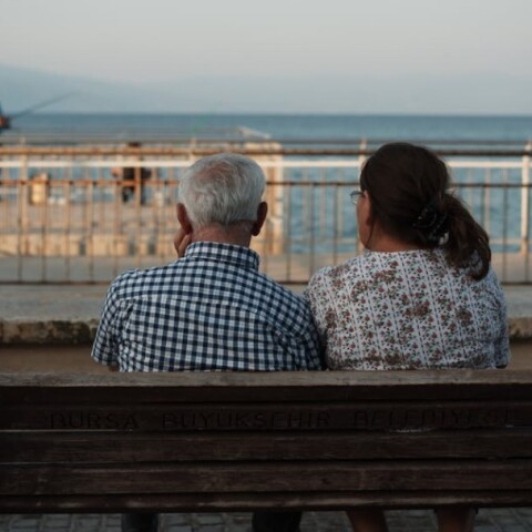 Συνταξιούχοι, καθισμένοι σε παγκάκι, κοιτούν τη θάλασσα