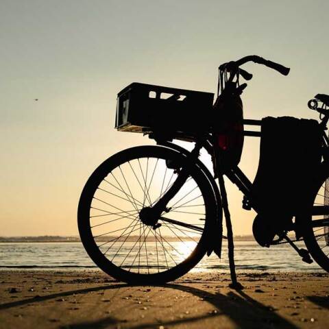 Ποδήλατο στην αμμουδιά με φόντο το ηλιοβασίλεμα