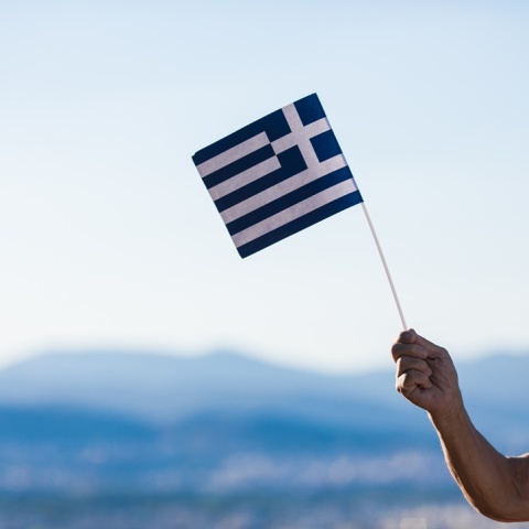 Χέρι κρατά ελληνική σημαία