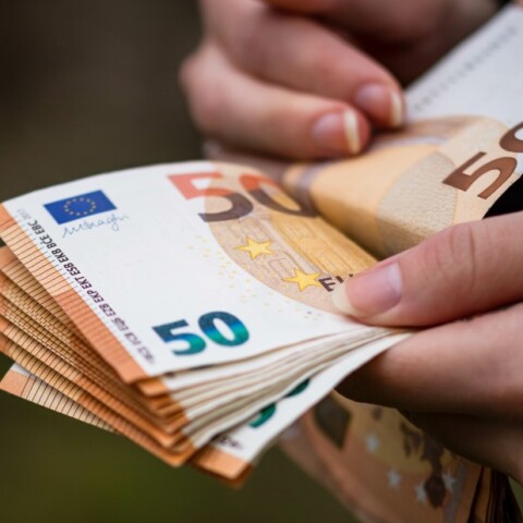 Άνδρας μετρά χαρτονομίσματα των 50 ευρώ