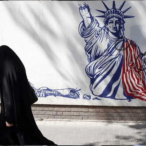 Γυναίκα περνά μπροστά από mural στην Τεχεράνη για τον πόλεμο Ιράν με ΗΠΑ