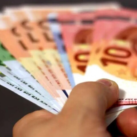 Χέρι κρατά χαρτονομίσματα ευρώ