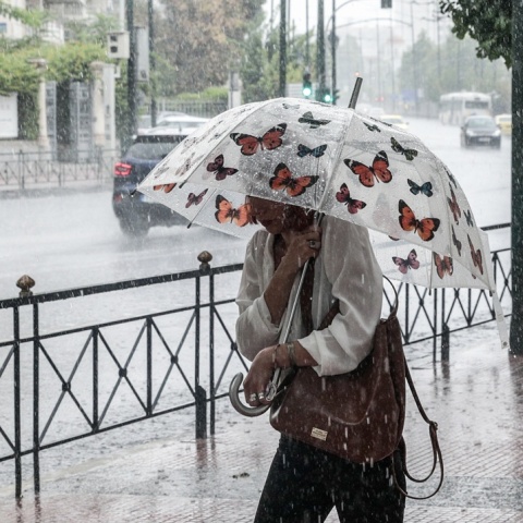 Γυναίκα με ομπρέλα εν μέσω βροχής