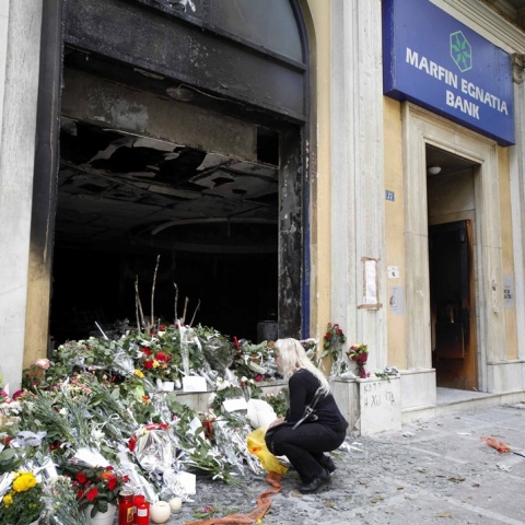 Λουλούδια έξω από τη Marfin λίγες ωρές μετά τον εμπρησμό και την τραγωδία με τους 3 νεκρούς