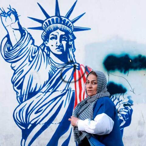 Γυναίκα περνά μπροστά από mural στην Τεχεράνη  με το άγαλμα της Ελευθερίας