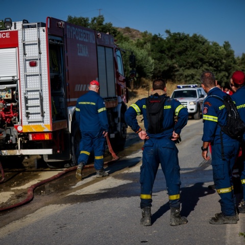 Πυροσβέστες δίπλα από όχημα
