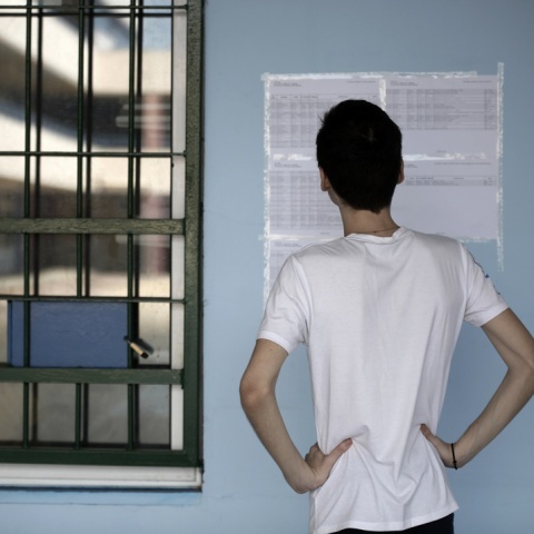Αγόρι βλέπει τις τοιχοκολλημένες βάσεις των πανελληνίων