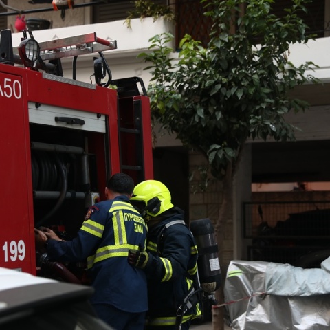 Πυροσβέστες πίσω από όχημα του Σώματος