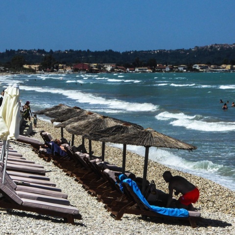 Πολίτες σε παραλία με έντονο κυματισμό και έντονο αέρα