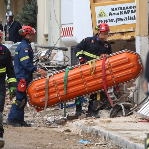 Διασώστες μεταφέρουν φορείο στα συντρίμμια για τη μεταφορά της σορού που εντοπίστηκε στην Πλάκα