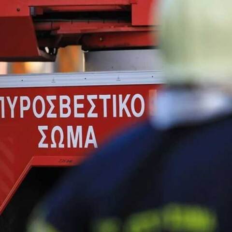 Πυροσβέστης μπροστά από πυροσβεστικό όχημα