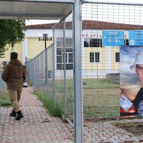 Πανό με τη φωτογραφία θύματος του σιδηροδρομικού δυστυχήματος στο κτίριο όπου εκδικάζεται η δίκη για τα Τέμπη