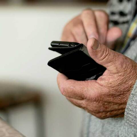 Συνταξιούχος με το κινητό τηλέφωνο στο χέρι