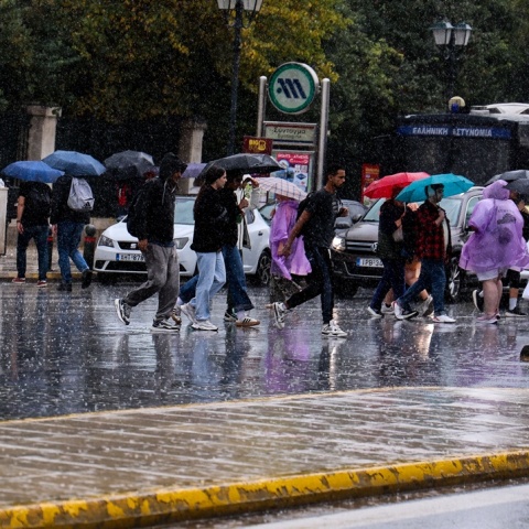 Πολίτες με ομπρέλες εν μέσω βροχής στο Σύνταγμα