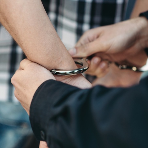 Αστυνομικός φορά χειροπέδες σε άτομο