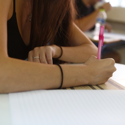 Υποψήφια των Πανελληνίων 2025 γράφει στο τετράδιο εξετάσεων