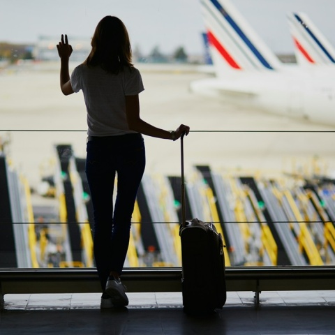 Γυναίκα με τη βαλίτσα της στο τζάμι αεροδρομίου