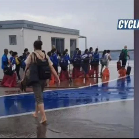 Επιβάτες μπαίνουν στο πλοίο στο λιμάνι της Τήνου ξυπόλητοι ή με σακούλες στα πόδια λόγω των κυμάτων