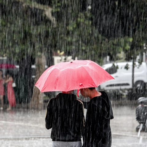 Πολίτες με ομπρέλες προστατεύονται από τη βροχή