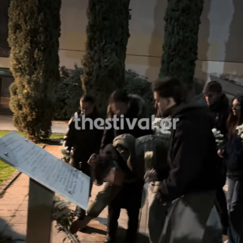 Φοιτητές αφήνουν στο μνημείο λίγα λουλούδια για τα θύματα της σιδηροδρομικής τραγωδίας στα Τέμπη