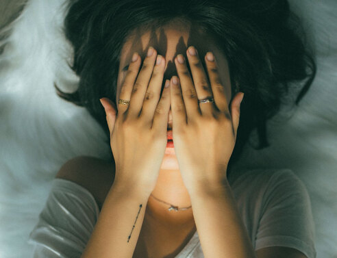 Κοπέλα κρύβει το πρόσωπό της με τα χέρια