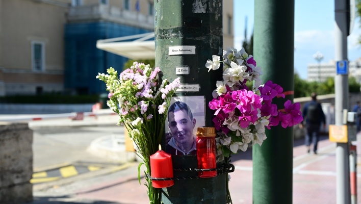 Λίγα λουλούδια και η φωτογραφία του Ιάσονα Λαλαούνη που σκοτώθηκε σε τροχαίο δυστύχημα έξω από τη Βουλή τον Μάρτιο του 2021