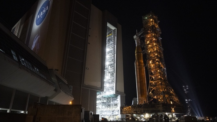 Μια φωτογραφία που διατέθηκε από τη NASA δείχνει τον πύραυλο Space Launch System (SLS) της NASA και το διαστημόπλοιο Orion, στερεωμένα στον κινητό εκτοξευτή, καθώς εκκινεί από το Κτίριο Συναρμολόγησης Οχημάτων προς την Εξέδρα Εκτόξευσης 39Β, στο Διαστημικό Κέντρο Κένεντι της NASA