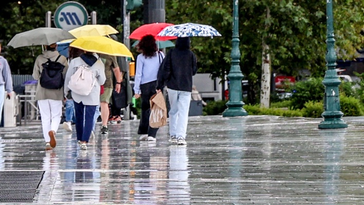 Πολίτες με ομπρέλες εν μέσω βροχής στο κέντρο της Αθήνας