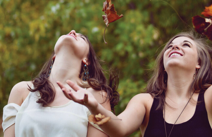 Κορίτσια παίζουν με πεσμένα φύλλα