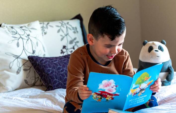Παιδί στο κρεβάτι που διβάζει βιβλίο