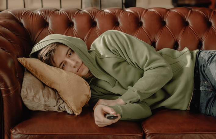 Άντρας στον καναπέ, βλέπει τηλεόραση