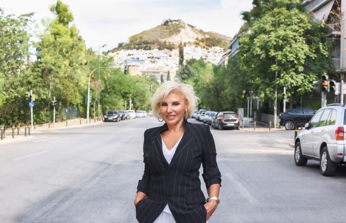 Η Πόπη Διαμαντάκου φωτογραφισμένη στη μέση του δρόμου με φόντο τον λόφο του Λυκαβηττού