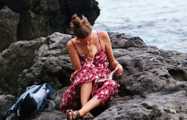 Κορίτσι που διαβάζει στην παραλία