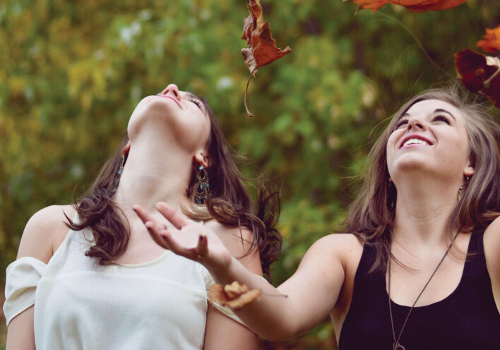 Κορίτσια παίζουν με πεσμένα φύλλα