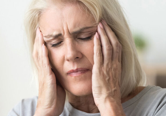Ηλικιωμένη γυναίκα πιάνει το κεφάλι της με τα χέρια