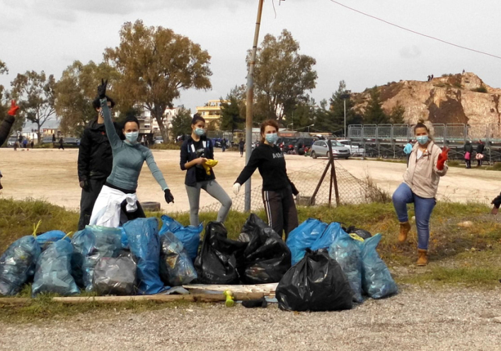 Οκτώ εθελοντές της ομάδας Save Your Hood με γεμάτες σακούλες σκουπιδιών