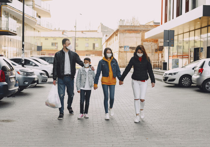 Οικογένεια πιασμένη από το χέρι περπατάει στο δρόμο