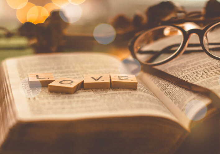 Ανοιχτό βιβλίο με ξύλινα γράμματα ακουμπισμένα που σχηματίζουν τη λέξη LOVE.