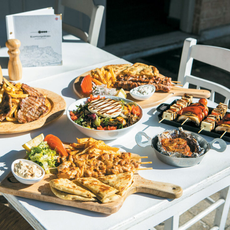 Στρωμένο τραπέζι με σαλάτες και ψημένα κρέατα