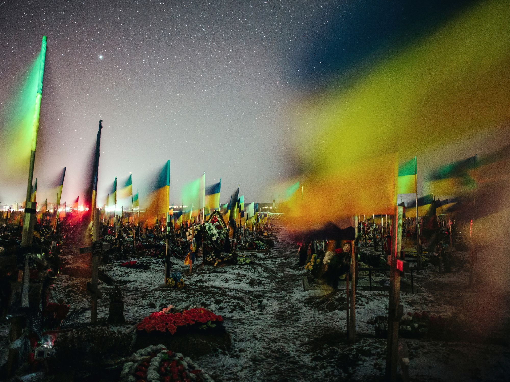 Ουκρανικές σημαίες κυματίζουν πάνω από τους τάφους Ουκρανών στρατιωτών σε ένα στρατιωτικό νεκροταφείο στο Χάρκοβο στις 22 Φεβρουαρίου 