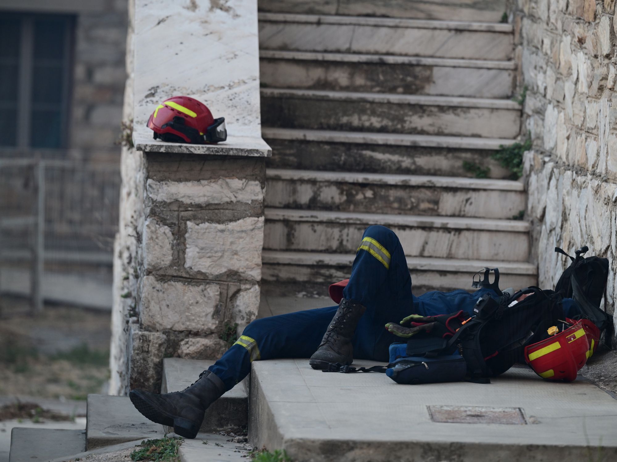 Αποκαμωμένος πυροσβέστης παίρνει λίγες ανάσες ξεκούρασης
