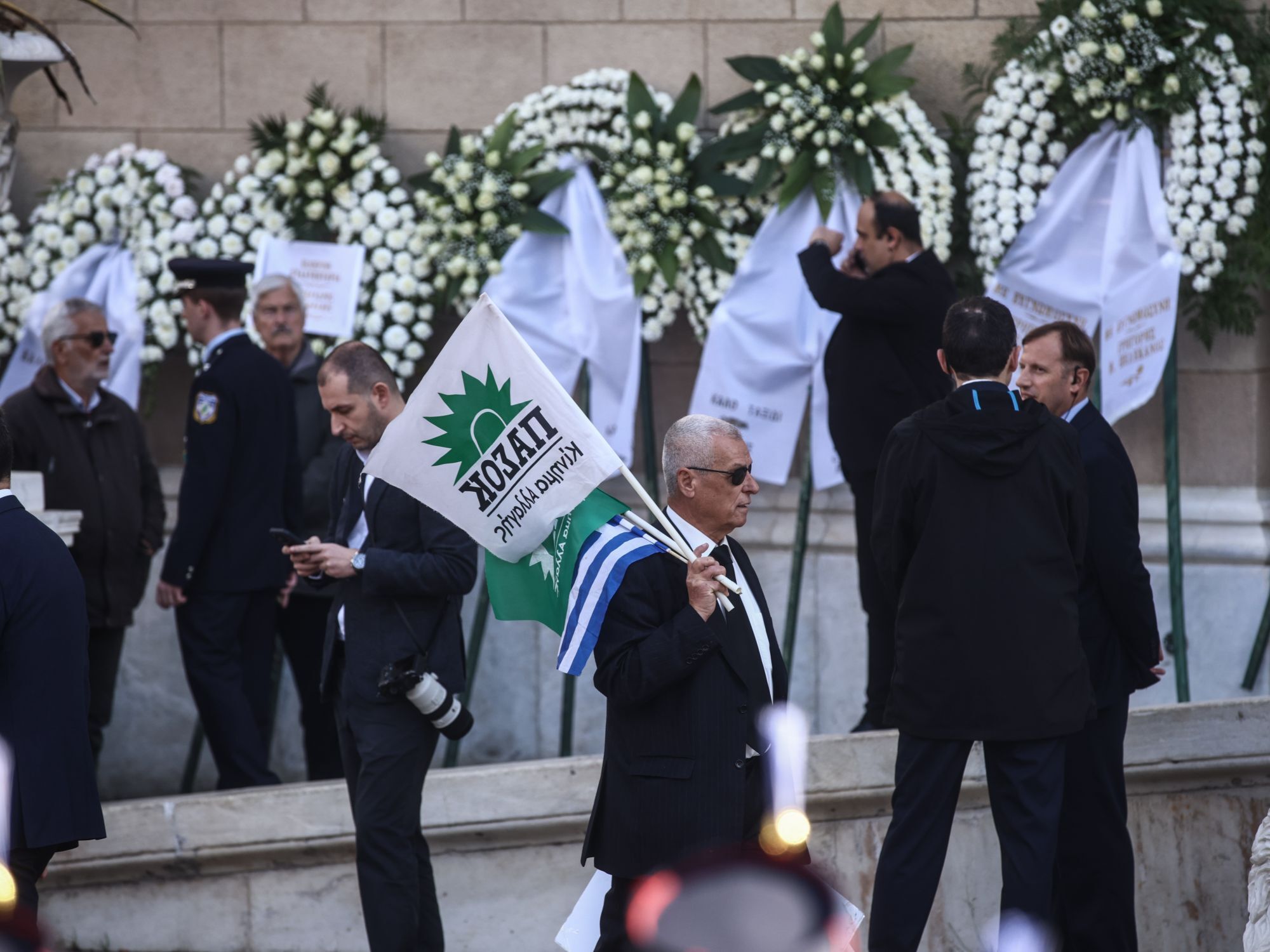 Πολίτες έξω από τη Μητρόπολη Αθηνών κρατώντας σημαίες του ΠΑΣΟΚ