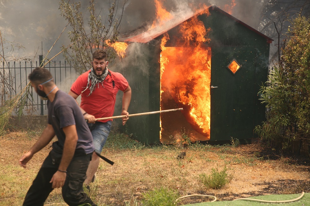 Εθελοντές συνδράμουν στην κατάσβεση της φωτιάς στην περιοχή Αφίδνες, στη Βόρεια Αττική. 