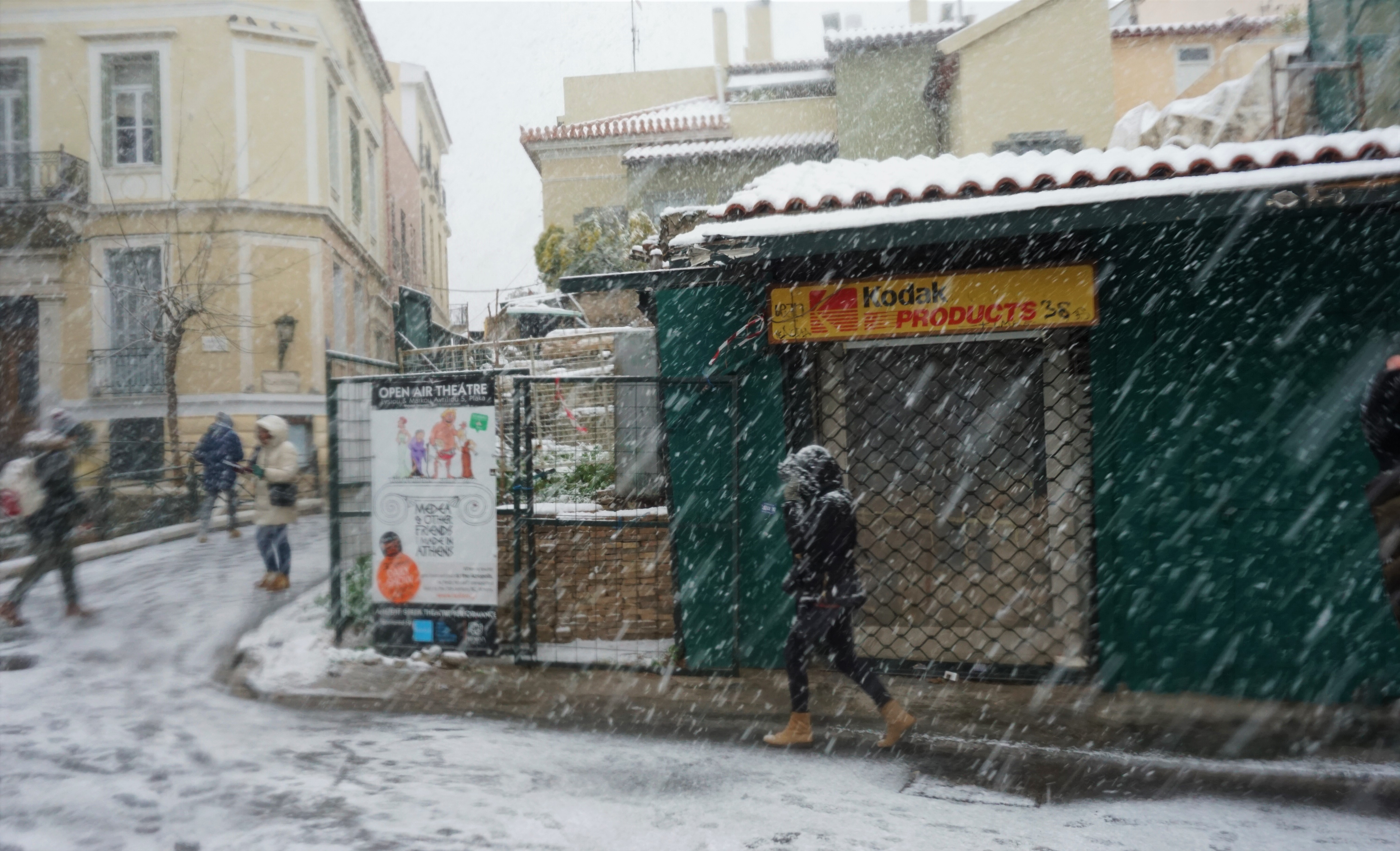 Ένας άνθρωπος περπατάει στην χιονισμένη Αθήνα. 
