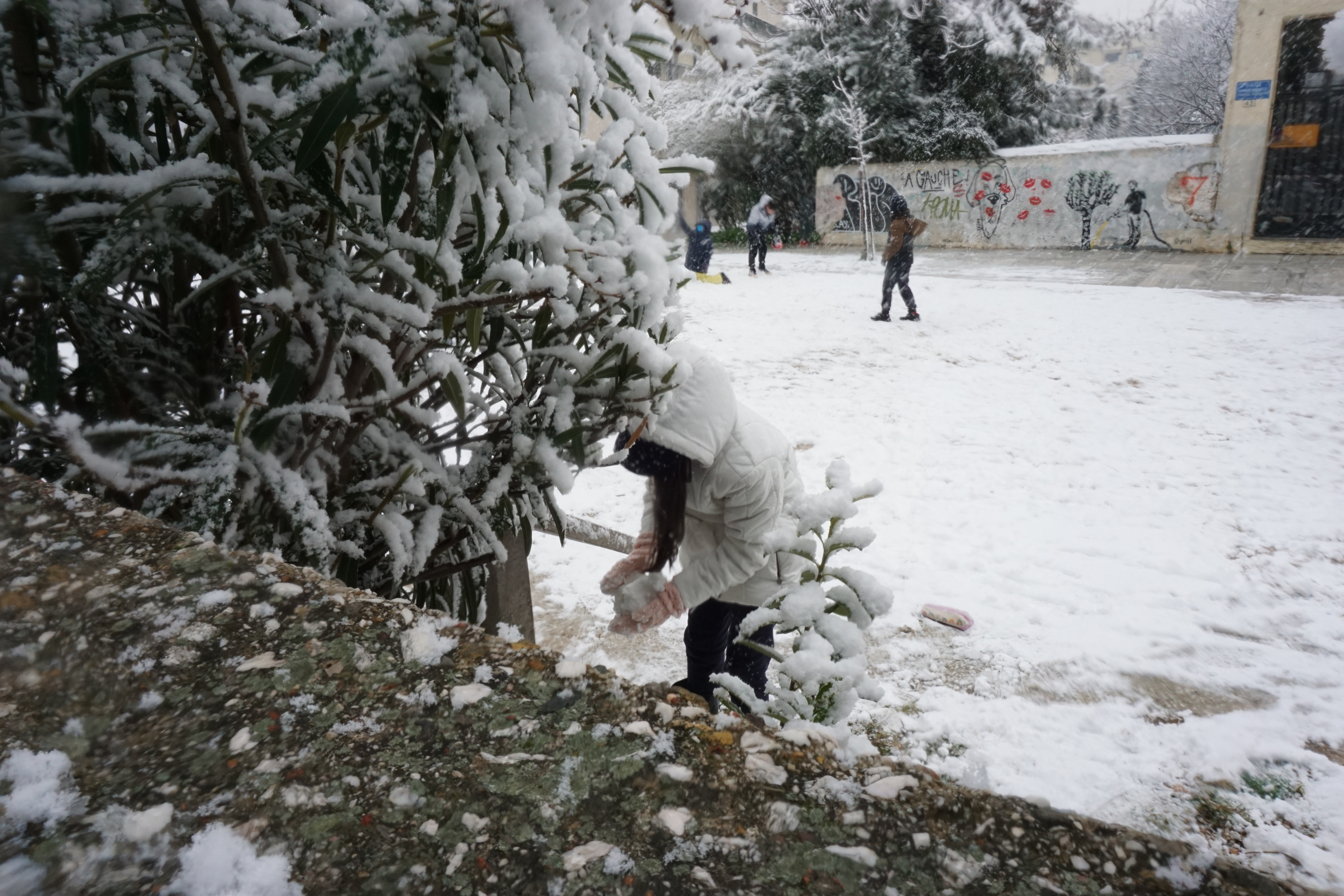 Ένα παιδί ετοιμάζεται να ρίξει μια χιονόμπαλα. 