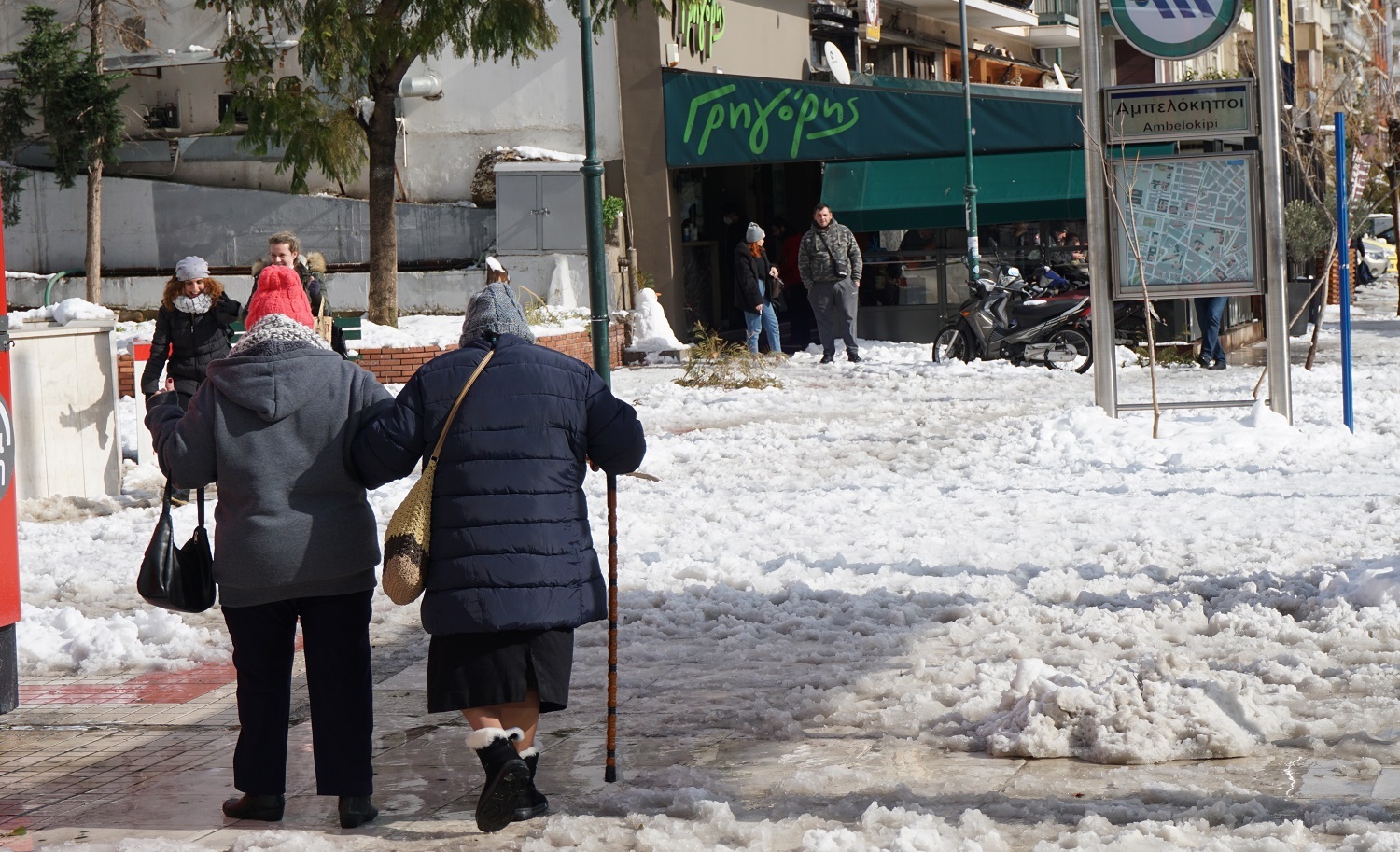 Δύο κυρίες περπατούν στο πεζοδρόμιο της Λεωφόρου Αλεξάνδρας.