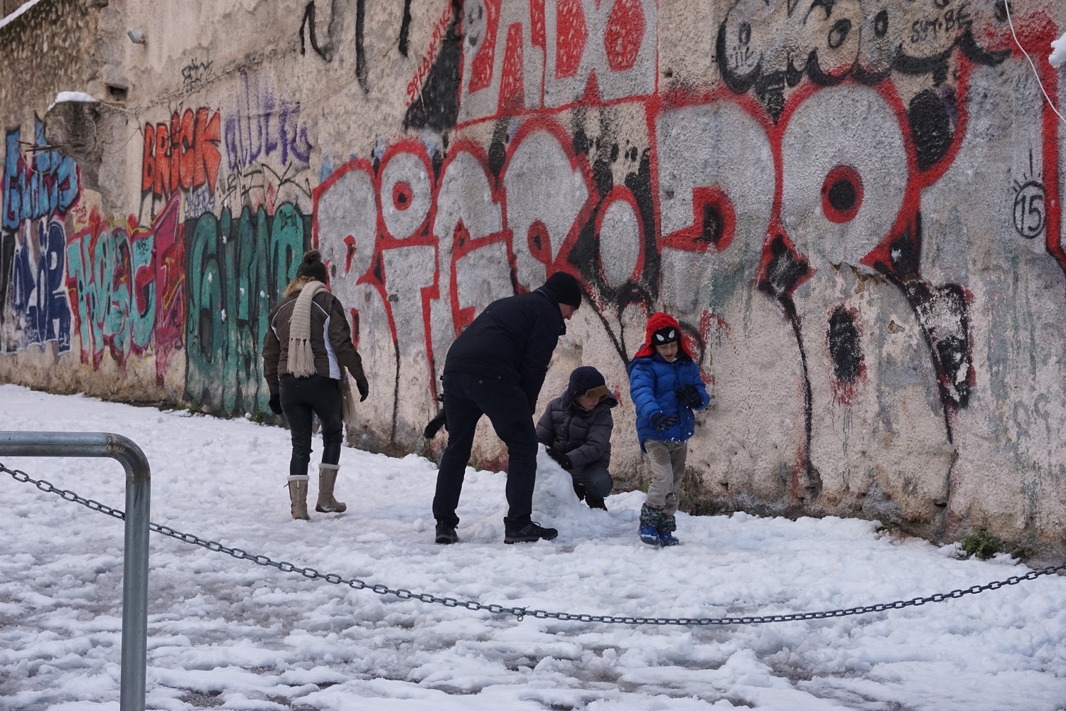 Μια οικογένεια φτιάχνει χιονάνθρωπο. 