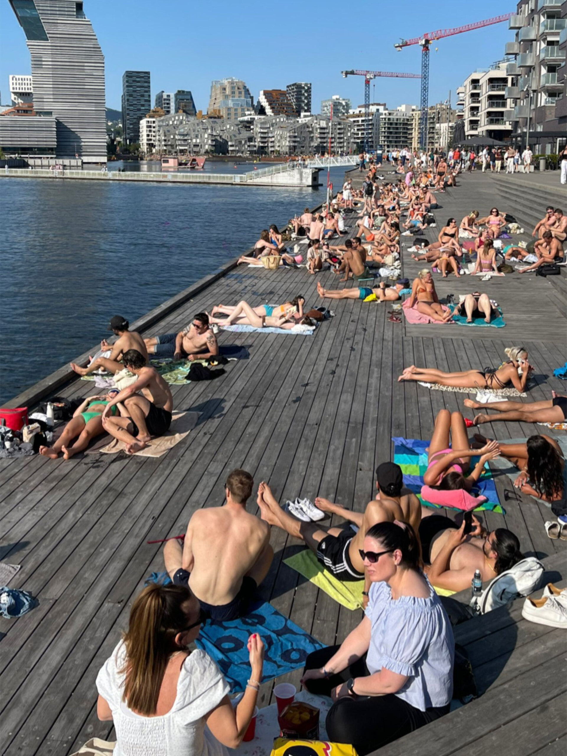 Νέοι στις δημόσιες εγκαταστάσεις της προκυμαίας κατασκευασμένης από ξύλινο deck στο Όσλο